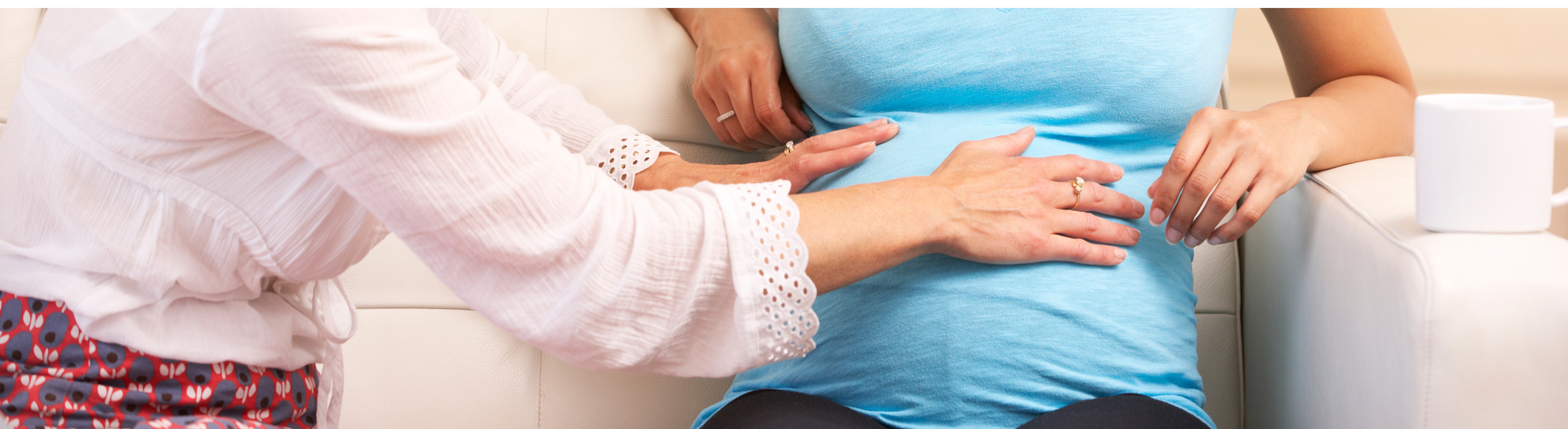 woman touching someone's pregnant belly