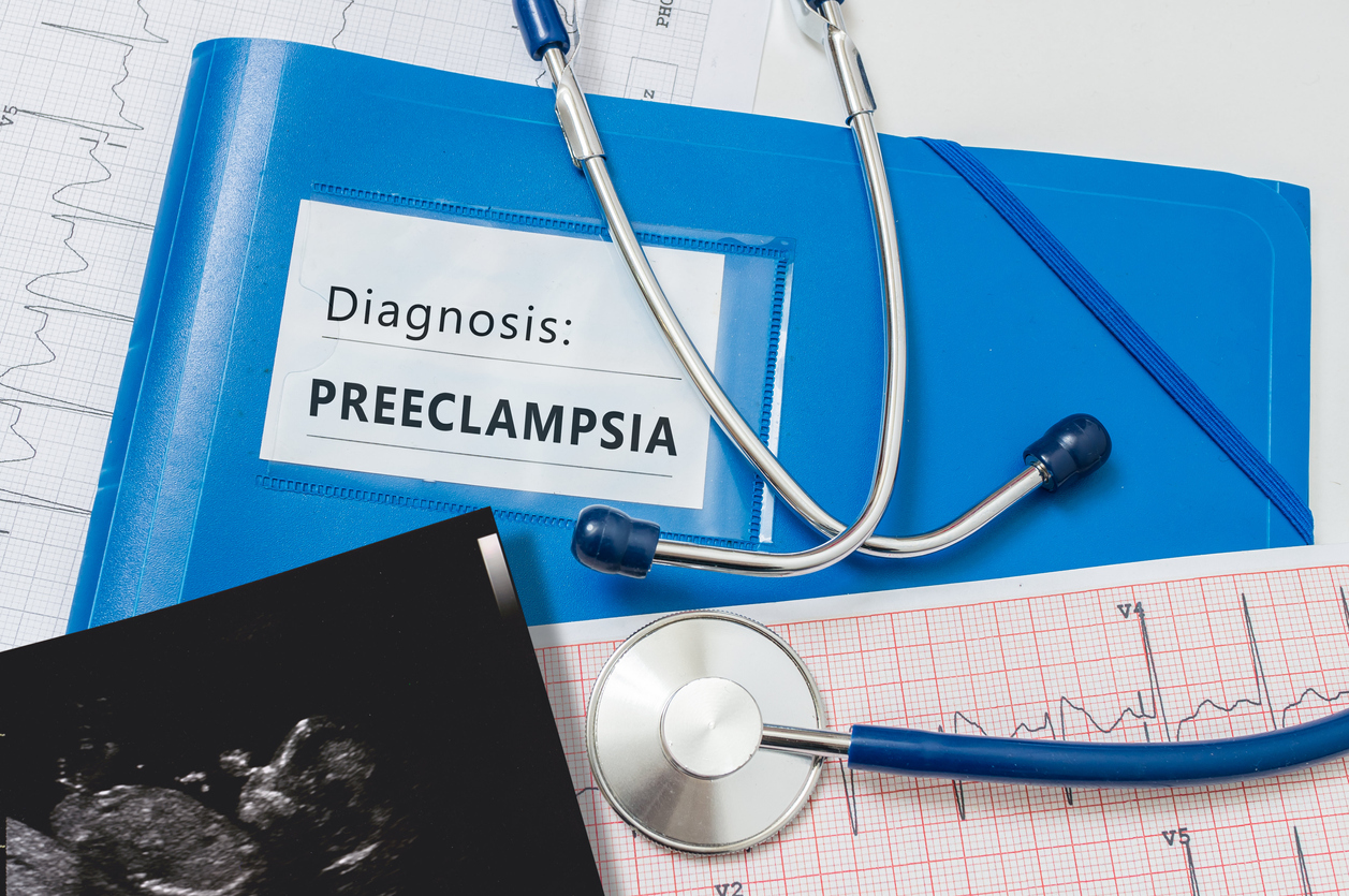 stethoscope, ultrasound photo of baby, binder with 'diagnosis: preeclampsia' written on it
